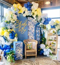 a blue and white wedding arch with balloons