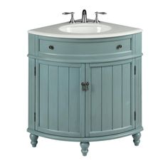 a bathroom vanity with a white sink and light blue wood cabinetry on the side