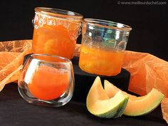 three jars filled with orange liquid next to slices of melon and an avocado