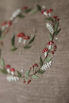 a close up of a piece of cloth with embroidered flowers and leaves on the fabric