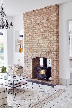 a living room filled with furniture and a fire place next to a brick wall fireplace