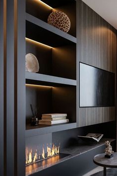 a living room with a fire place and bookshelves on the wall next to it