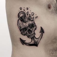 a man's chest with a skull and an anchor tattoo on his left side