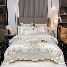 a bed with white comforter and pillows in a room next to a book shelf