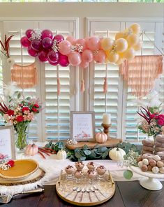 the dessert table is decorated with balloons and other decorations