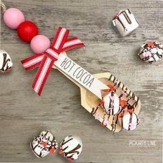 a wooden spoon with chocolate covered donuts on it next to some candy candies