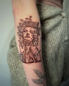 a woman's arm with a tattoo on it that has an image of a woman