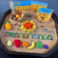 an assortment of fruits and vegetables are on a tray with matching magnets to help children learn how to read