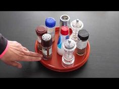 a person is holding their hand over an assortment of medicine bottles on a red tray