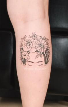 a woman's leg with flowers on her head and the words lotus tattooed on it