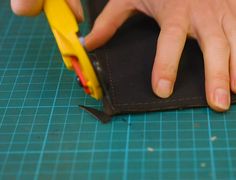 a person is cutting up a piece of fabric with scissors and glue on the edge