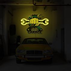 a yellow car in a garage with a wrench on it's front end