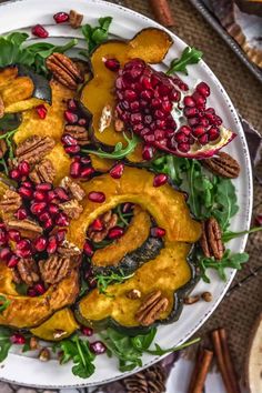 a white plate topped with squash and pomegranate