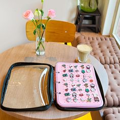 two pieces of luggage sitting on top of a table next to a vase with flowers