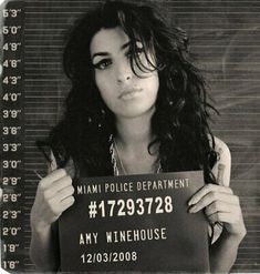 a black and white photo of a woman holding a sign that says miami police department