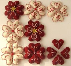 several red and white paper flowers are arranged on a white surface with gold star in the center