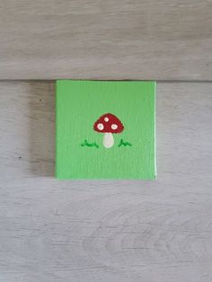 a small green painting with a mushroom on it