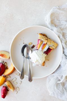 a piece of pie on a plate with ice cream and sliced peaches next to it