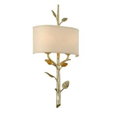 a lamp with a white shade on top of it and leaves around the base,