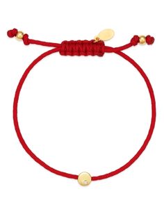 a red string bracelet with two gold charms