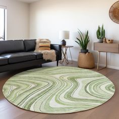 a living room with a black couch and green rug