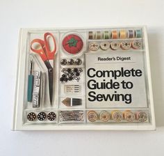 the complete guide to sewing with scissors and other crafting supplies in it's tray