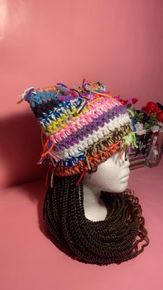 a mannequin head wearing a multicolored hat