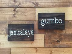 two wooden signs that say gumbo and jambajaya on wood planks