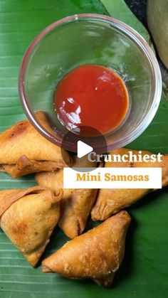 some food that is on a banana leaf with ketchup and sauce in a bowl