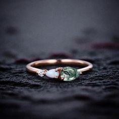 a close up of a gold ring with a green and white stone in the middle