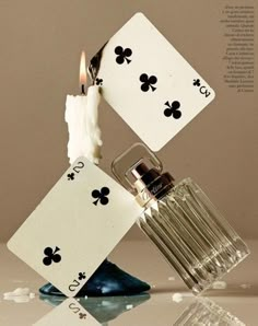 an ace playing card falling into water with its reflection on the table and it's bottle upside down