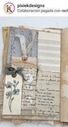 an open book with papers and tags on it's cover, including paper flowers