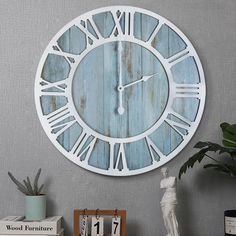 a large clock on the wall with roman numerals and blue woodgrain