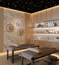 a spa room with two massage tables and lights on the wall