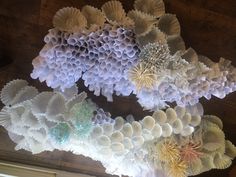 several different types of paper flowers hanging from the ceiling