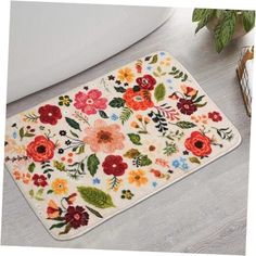 a bathroom rug with flowers and leaves on it