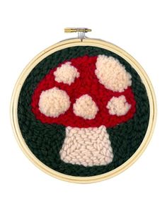 a crocheted mushroom with hearts on it's face in a round frame