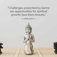 a buddha statue sitting on top of a wooden table next to black and white rocks