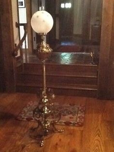 an old fashioned lamp is on the floor in front of a mirror and door way