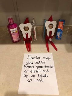 two toothbrushes are sitting next to a sign that reads santa says you better brush your teeth or they'll each up so close as cool