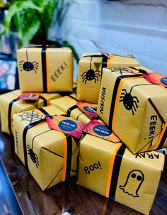 several boxes with halloween decorations on them sitting on a table next to a potted plant