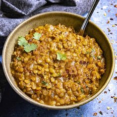 a bowl filled with lentils and garnished with cilantro