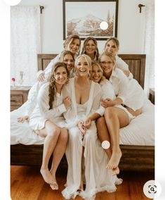 a group of women sitting on top of a bed