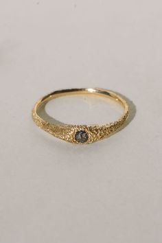 a gold ring with a black diamond on it