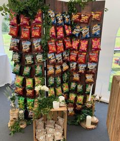 an assortment of snacks displayed on display in front of a wooden stand with plants and candles