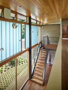 the inside of a house with wooden floors and stairs leading up to an open floor plan