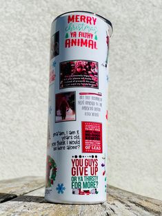 a can of merry and ugly animal on top of a wooden table with snowflakes