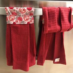 two red towels hanging on a towel rack