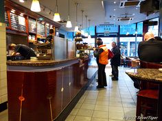 people are standing at the counter in a restaurant