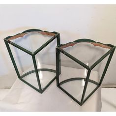 two green glass vases sitting on top of a white table